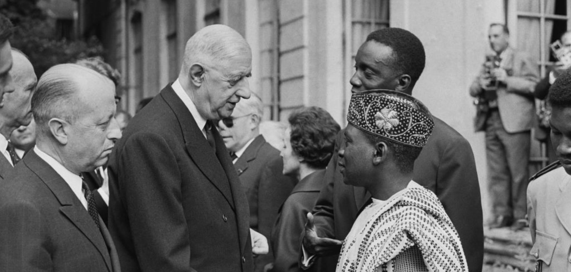 A picture released on July 12, 1963, of then-French President Gen. Charles de Gaulle (2L) and Jacques Foccart (L) greeting African, Malagasy and French overseas territories veterans arriving in Paris for French Bastille Day celebrations.