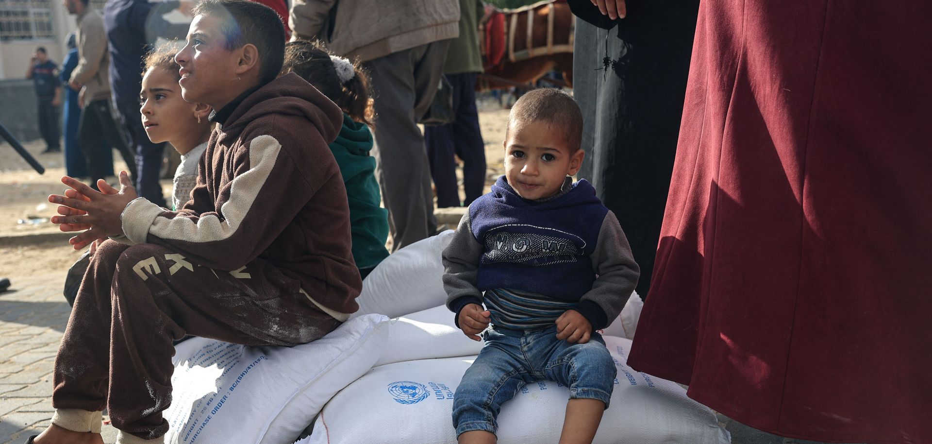 Palestinians receive bags of flour at the U.N. Relief and Works Agency for Palestine Refugees (UNRWA) distribution center in the Rafah refugee camp in the southern Gaza Strip on Nov. 21, 2023. 