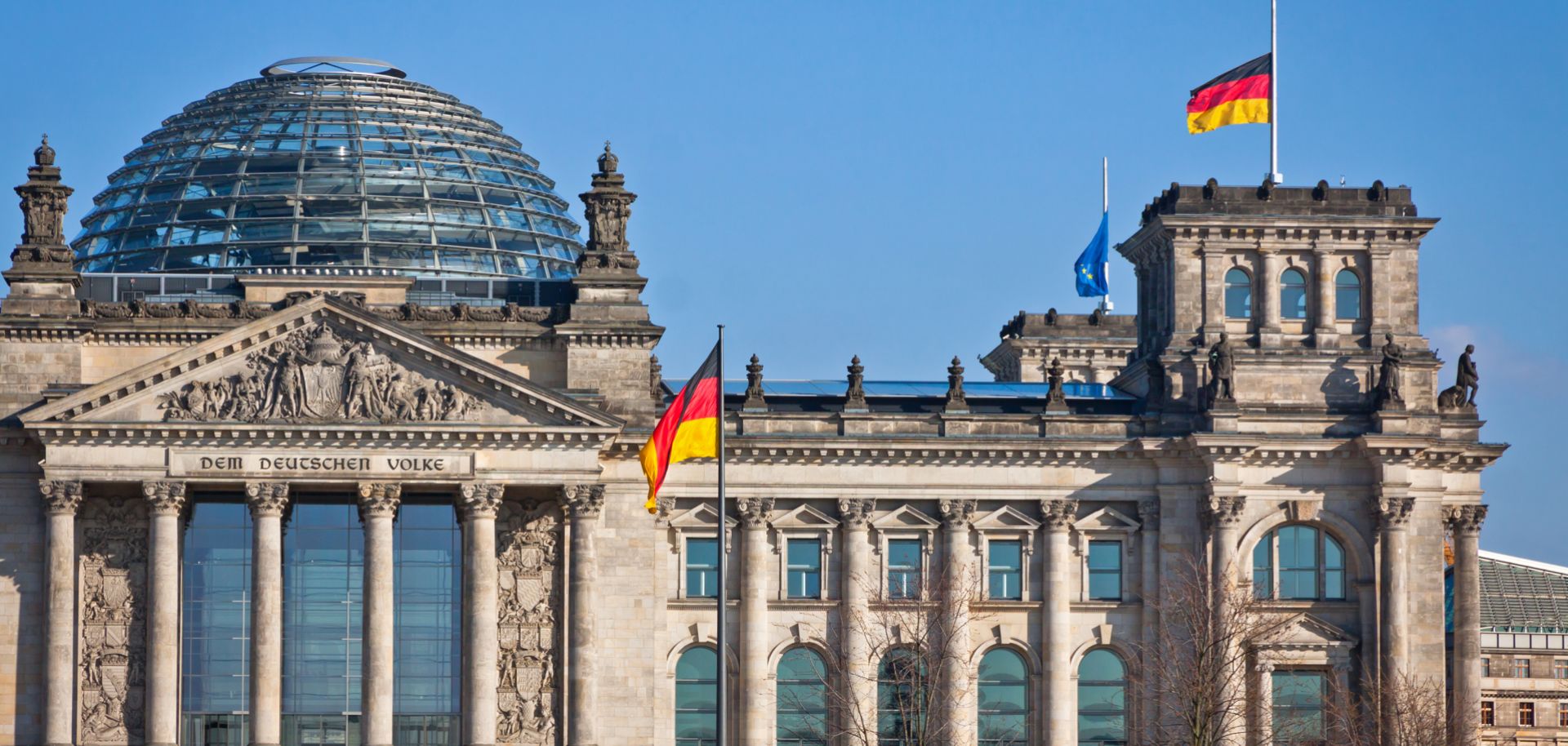 German flags are seen waving in front of the country’s parliament building in Berlin, Germany.