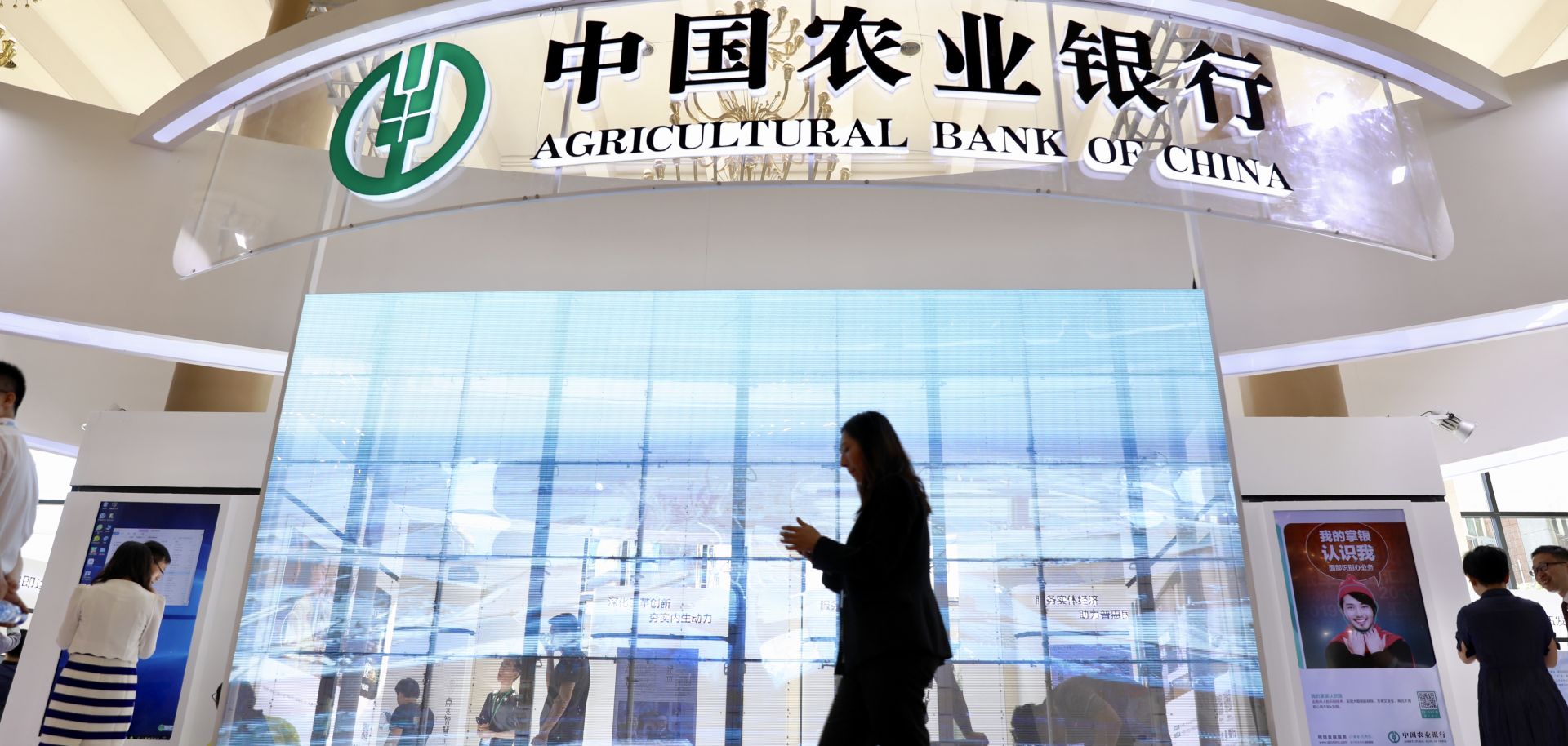  woman walks by the Agricultural Bank of China stand during the financial services exhibition of 2019 China International Fair for Trade in Services (CIFTIS).