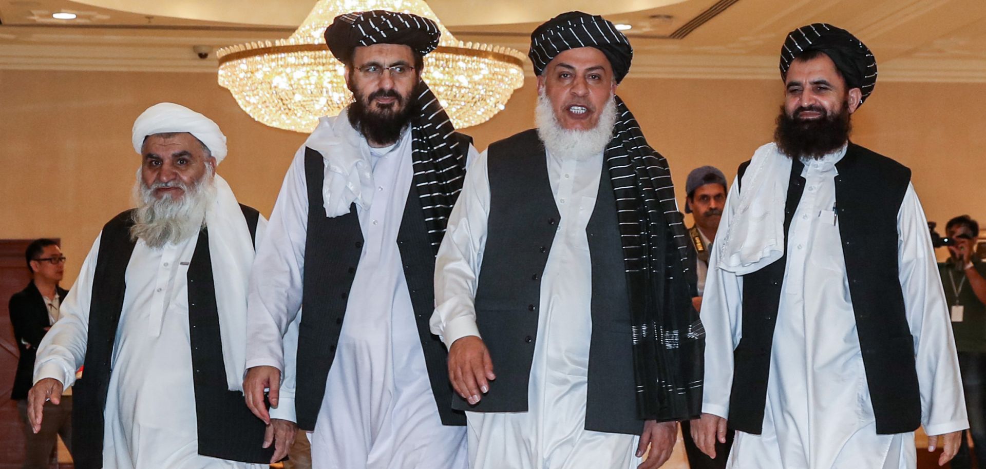 Mohammad Nabi Omari (C-L), a Taliban member formerly held by the United States at Guantanamo Bay, Taliban negotiator Abbas Stanikzai (C-R) and former Taliban intelligence deputy Mawlawi Abdul Haq Wasiq (R) walk with another Taliban member during the second day of the Intra-Afghan Dialogue talks in Doha on July 8, 2019.