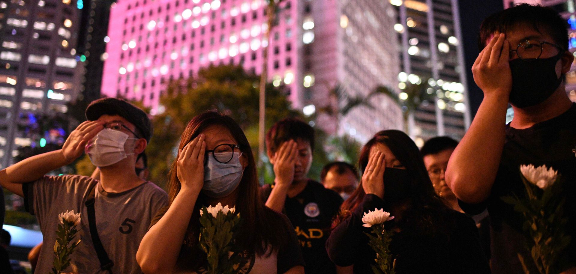 Protesters cover their right eyes as they attend the Stand in Silence for the 74th Anniversary of the Liberation of Hong Kong event at the cenotaph in Hong Kong on Aug. 30, 2019. 