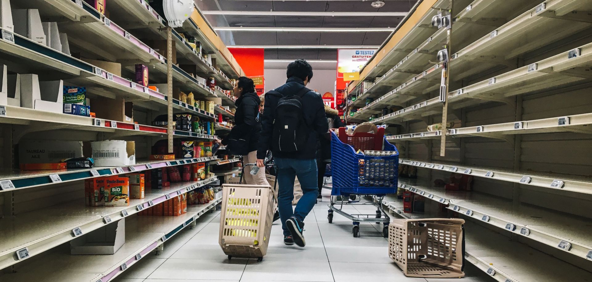 A man pulls a shopping trolley down a near-empty aisle in a supermarket in Paris, France, on March 2, 2020. Supermarket shelves in countries affected by the COVID-19 pandemic have been emptied of basic food necessities in recent weeks, such as pasta and rice. 