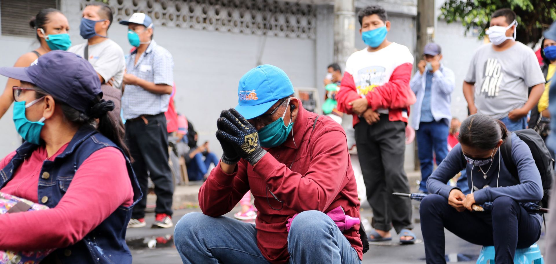 Peruvians wearing masks to protect themselves from COVID-19 wait outside a bank to collect government aid bonuses in Iquitos, Peru, on June 15, 2020. 