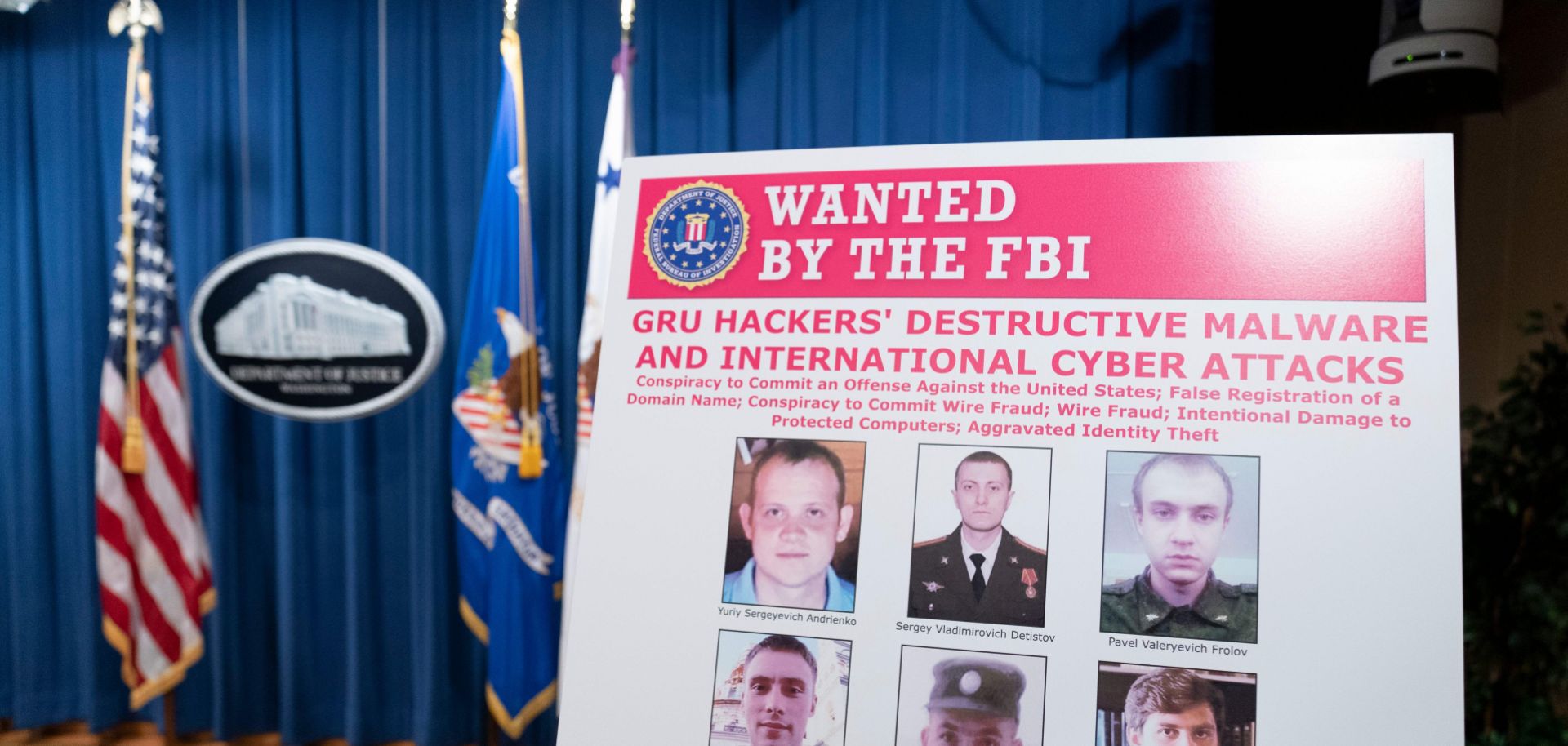 A poster showing six Russian intelligence officers charged with carrying out global cyberattacks is displayed before a news conference at the U.S. Department of Justice on Oct. 19, 2020, in Washington D.C. 