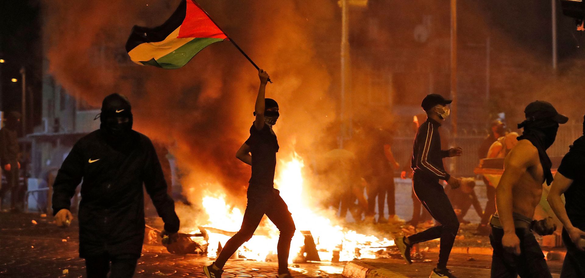 Palestinian protesters hurl stones during clashes with Israeli forces in Israeli-annexed east Jerusalem on May 14, 2021. 