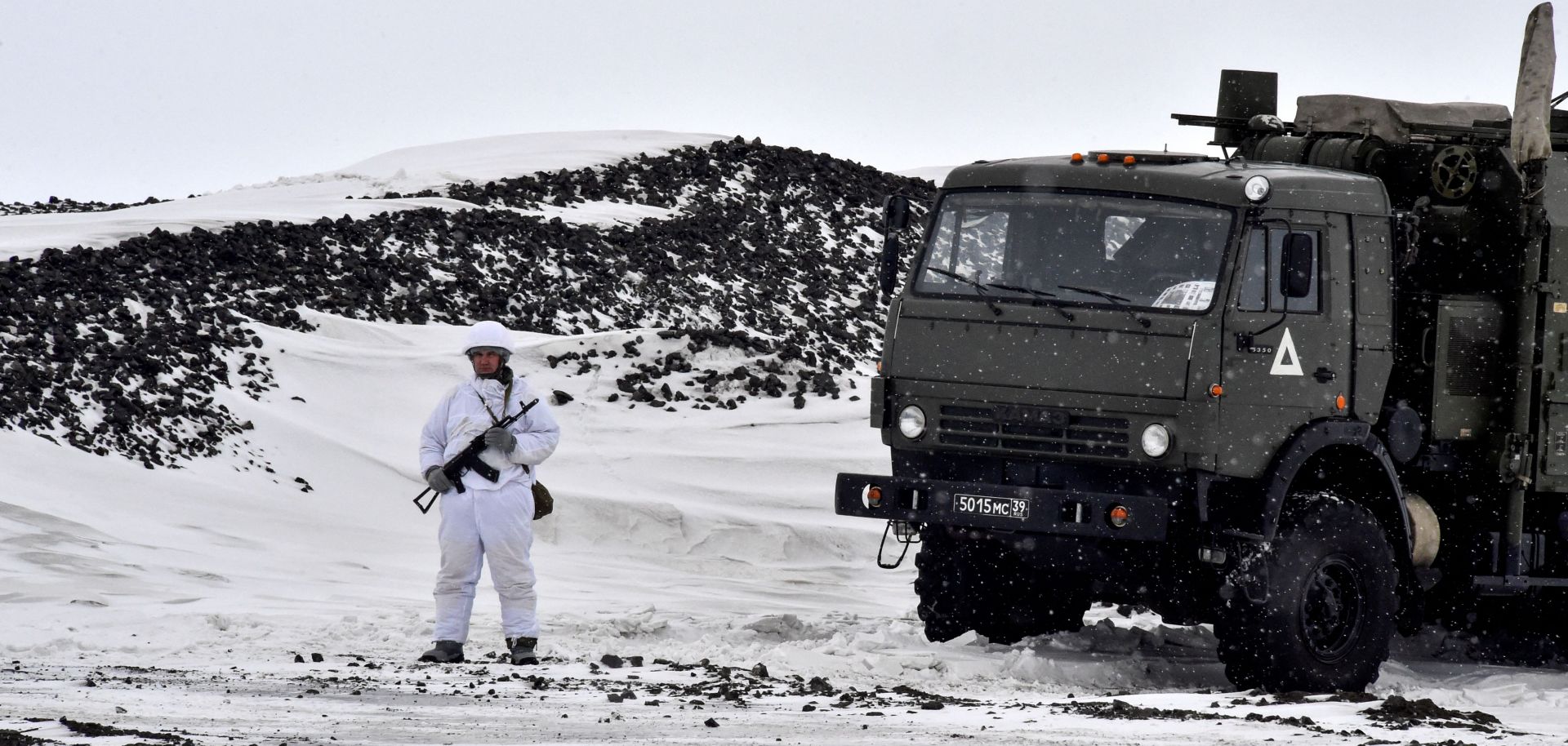 A Russian serviceman stands guard by a military truck on Alexandra Land, the largest island in Russia's Franz Josef Land archipelago in the Arctic Ocean, in May 2021.  