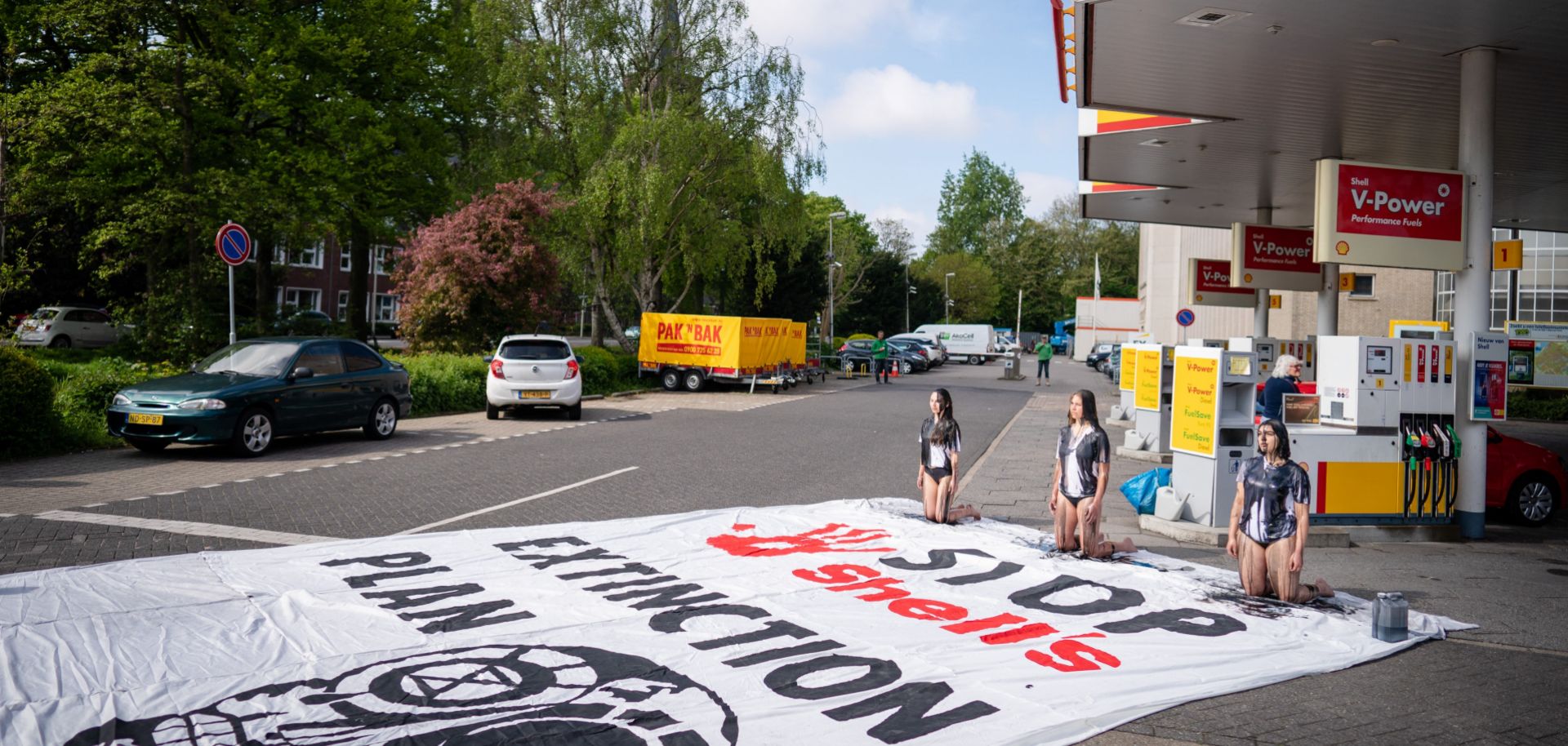 Environmental activists covered in black paint take part in a demonstration at a Shell gas station in The Hague, Netherlands, on May 18, 2021. 