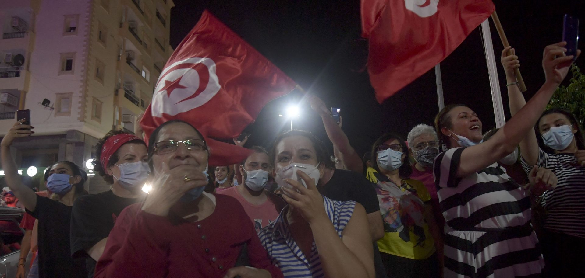 People celebrate in the streets of Tunis after Tunisian President Kais Saied announced the suspension of parliament and the dismissal of the country’s prime minister on July 25, 2021.