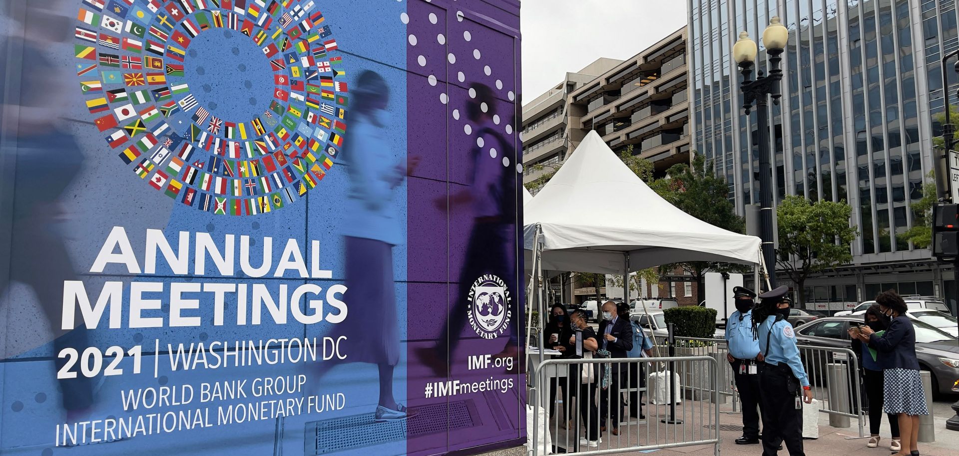 People wait outside the entrance to the annual meetings of the World Bank and International Monetary Fund (IMF) outside the IMF headquarters in Washington D.C. on Oct. 11, 2021. 