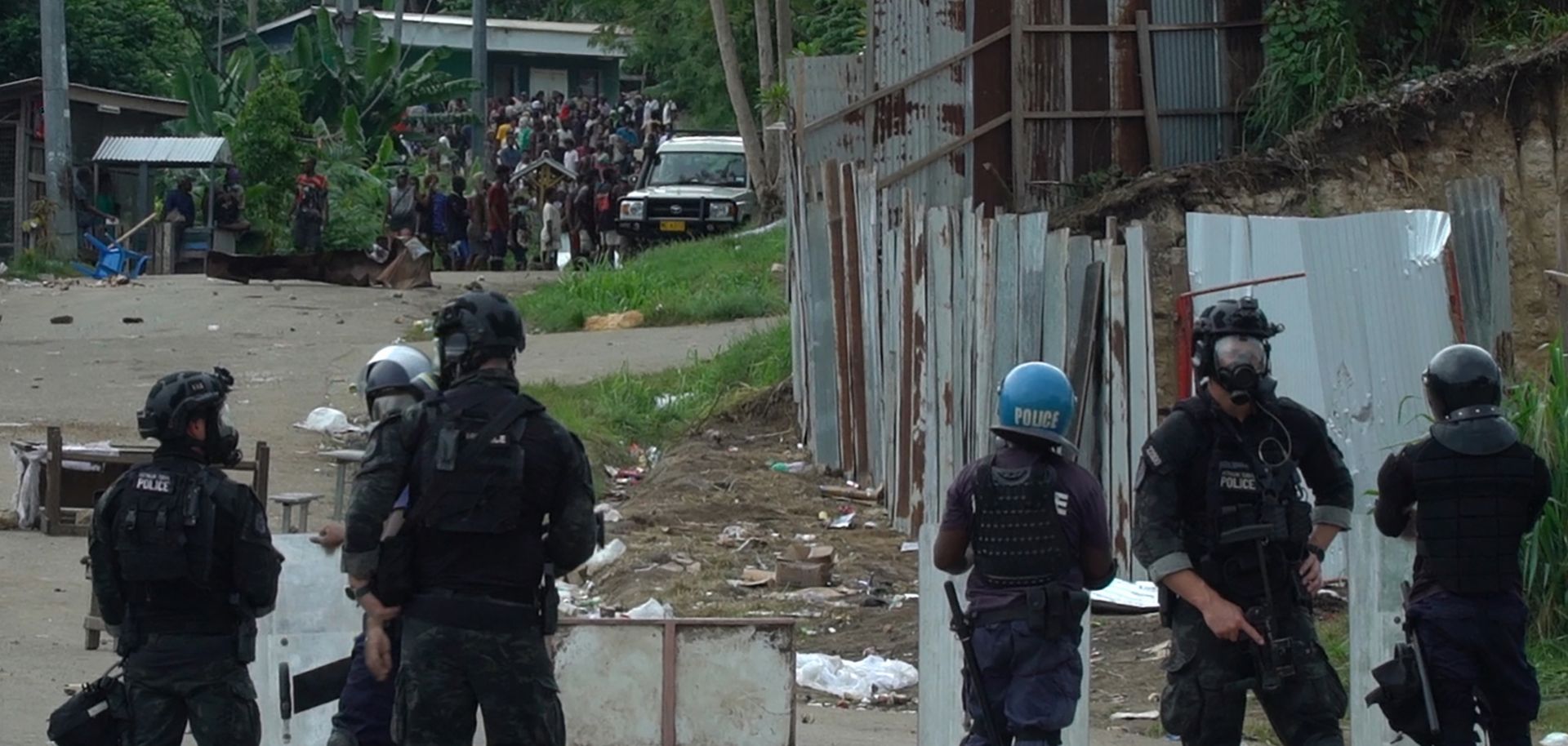 A frame grab from video footage shows Australian Federal Police officers and local police monitoring a crowd in Honiara, the capital of the Solomon Islands, on Nov. 26, 2021. 