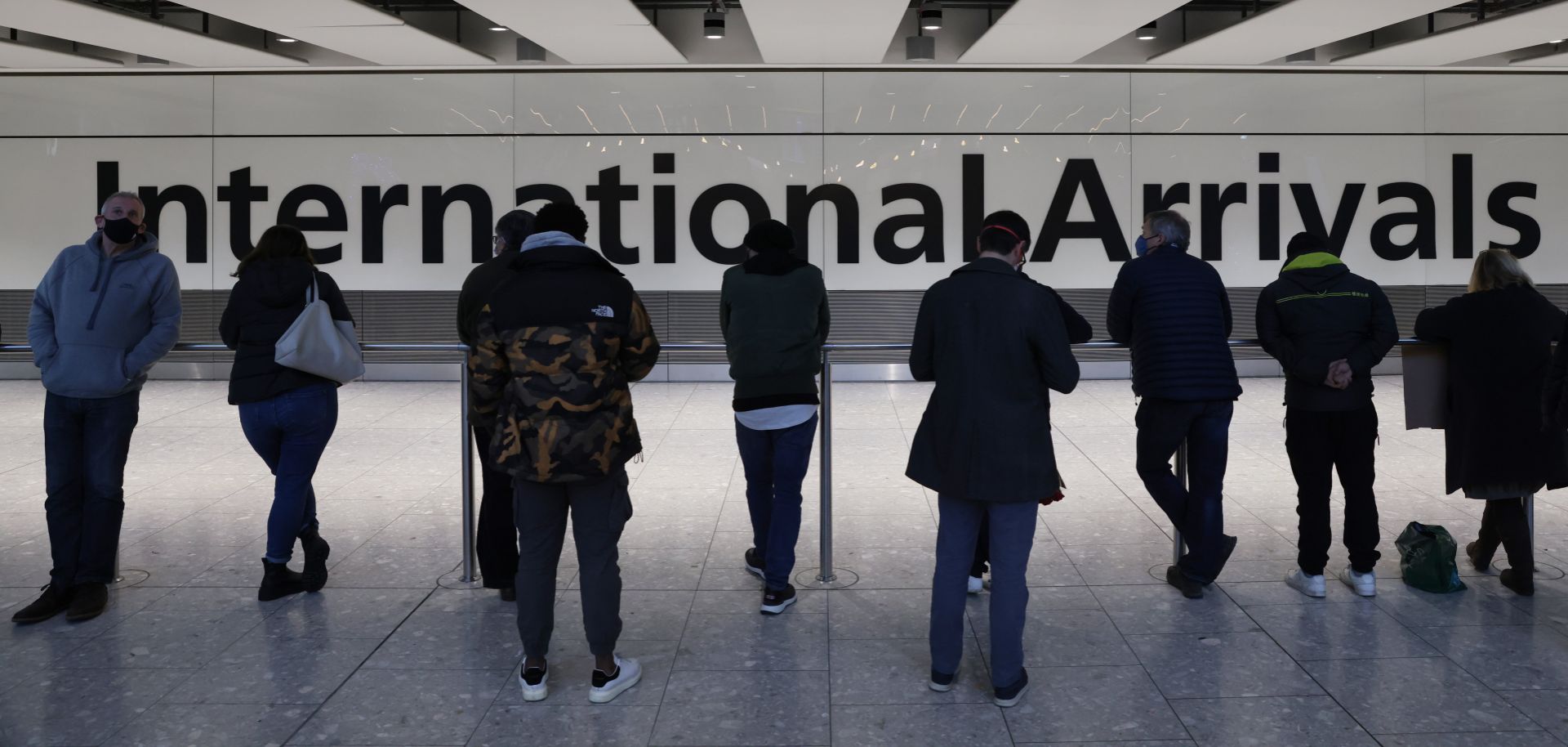 People wait at the international arrivals gate at London’s Heathrow Airport on Nov. 28, 2021. The United Kingdom recently imposed new travel restrictions following the discovery of the Omicron COVID-19 variant. 