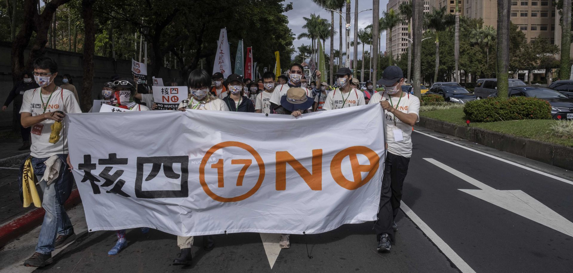 Activists march down a street in Taipei, Taiwan, to protest restarting construction on a nuclear power plant on Dec. 4, 2021. 