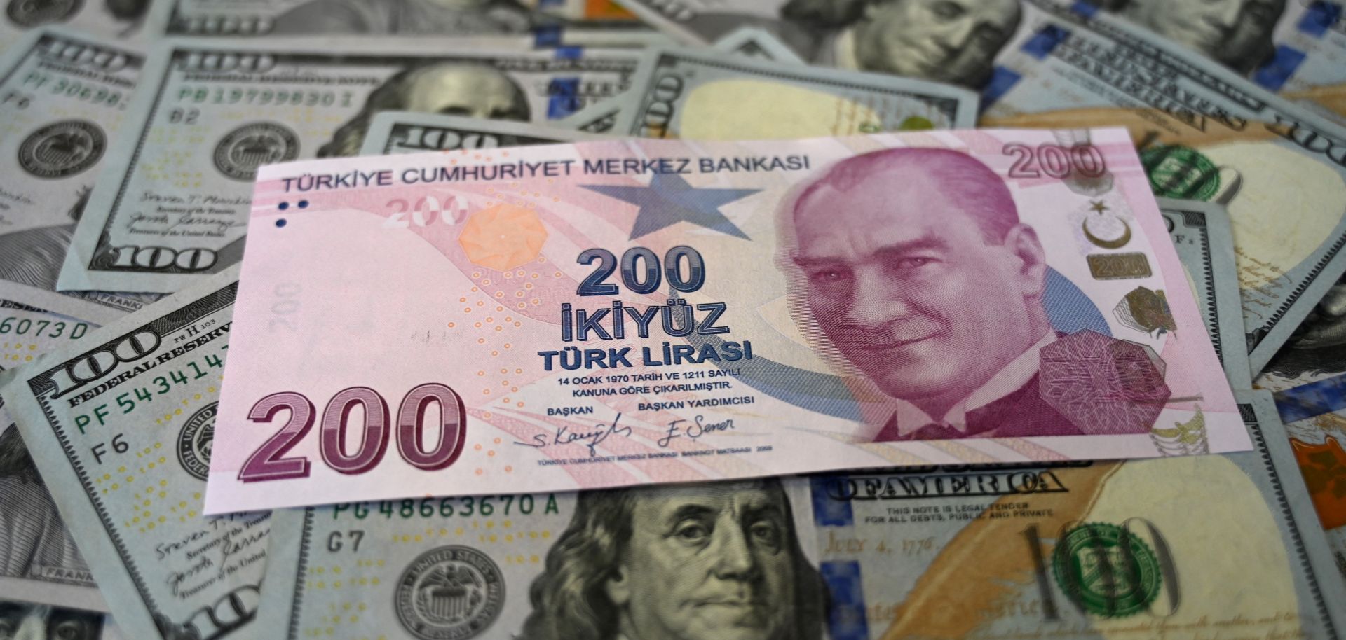 A Turkish lira banknote is seen on top of U.S. dollar banknotes in Istanbul, Turkey, on Dec. 7, 2021. 
