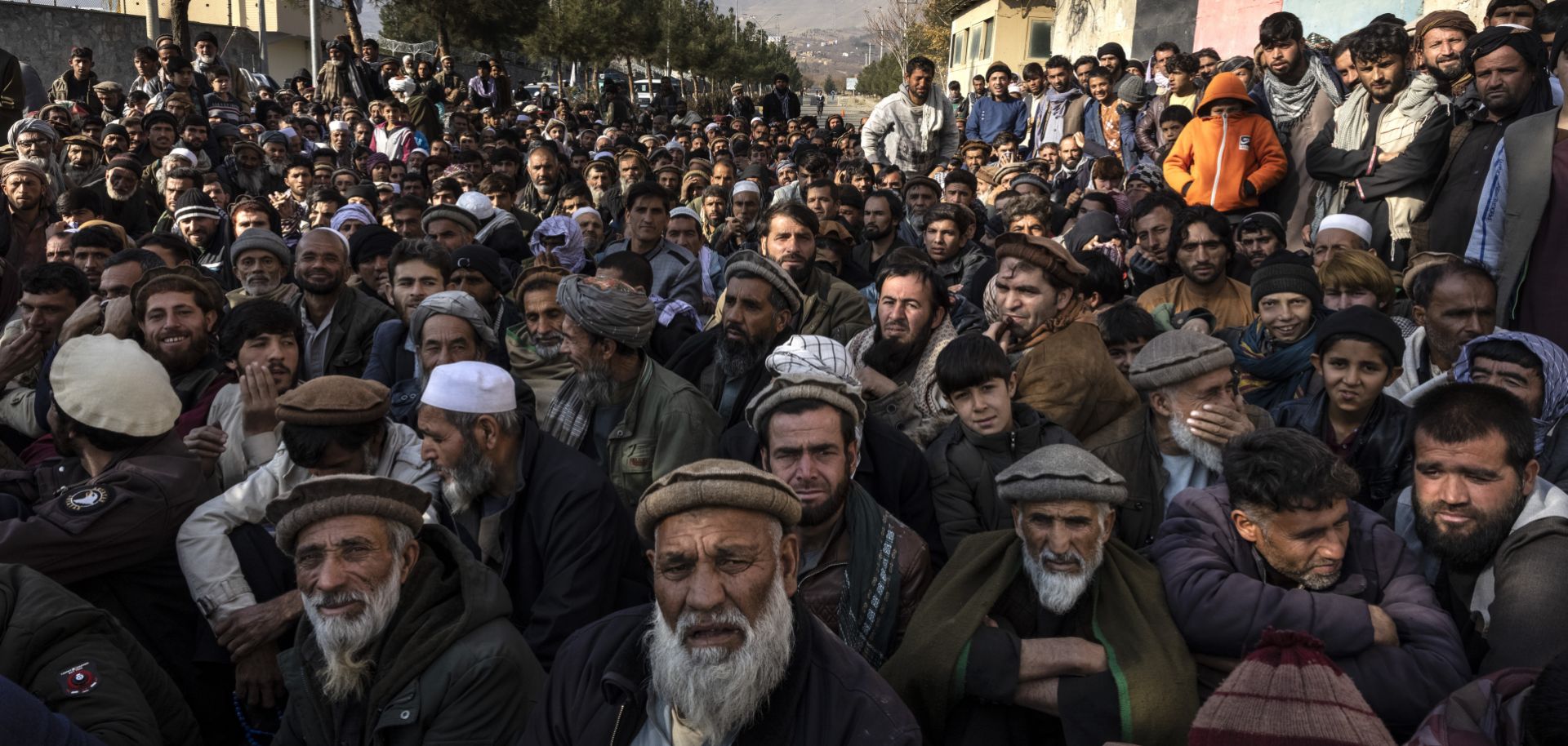 Hundreds of villagers desperate for humanitarian aid wait for hours outside a government center to register on Dec. 6, 2021, in Charikar, Afghanistan. 