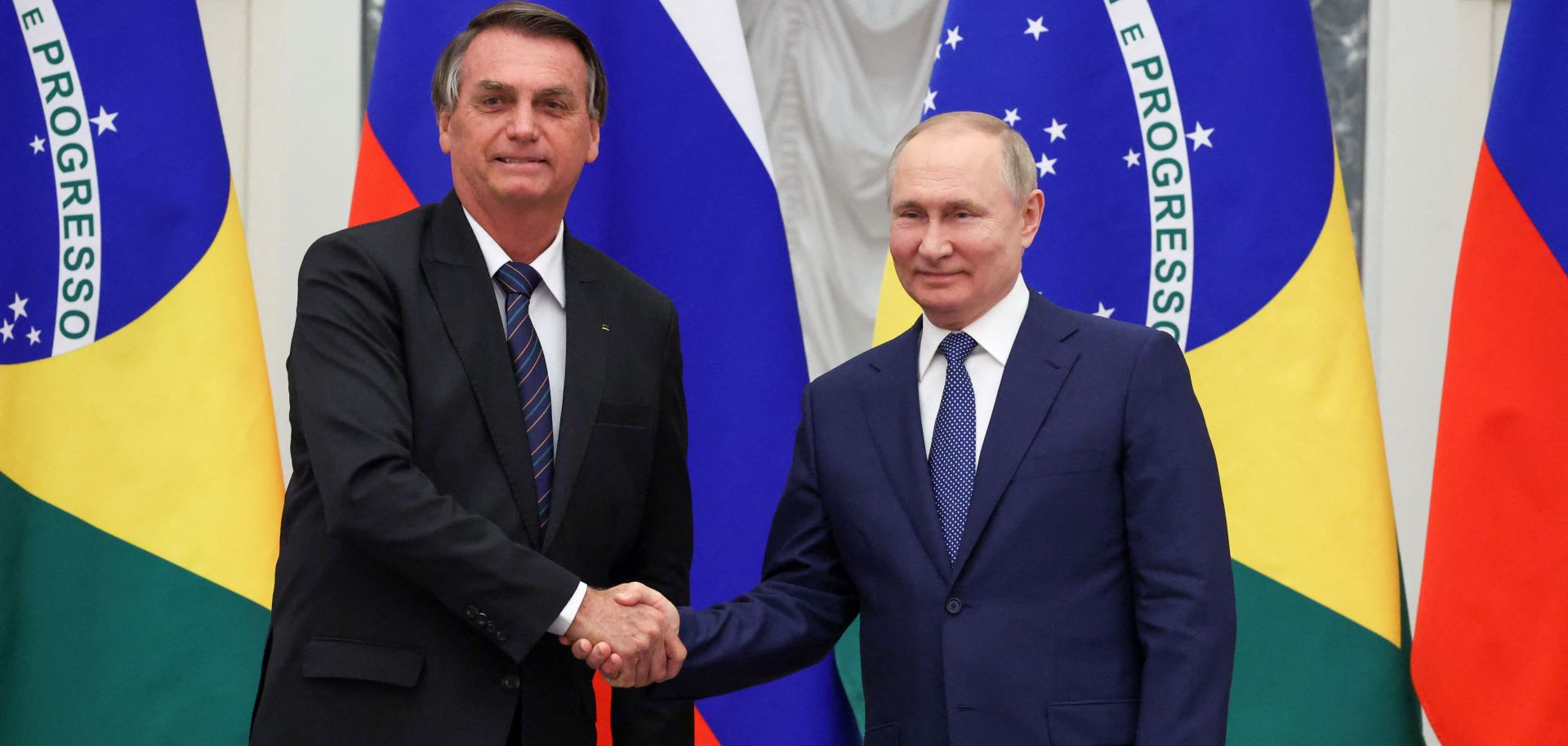 Russian President Vladimir Putin (right) shakes hands with Brazilian President Jair Bolsonaro during a joint press conference after holding a meeting in Moscow on Feb. 16, 2022. 