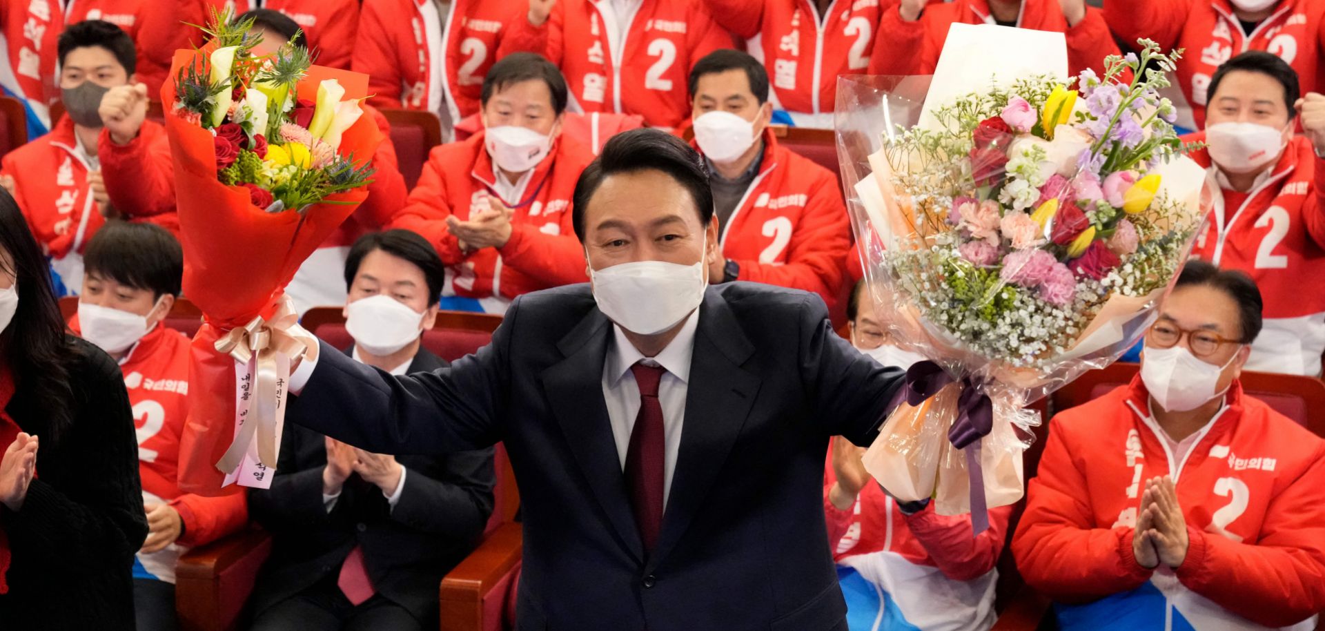 South Korean President-elect Yoon Suk Yeol holds bouquets as he is congratulated by members of his People Power Party at the National Assembly in Seoul, South Korea, on March 10, 2022.