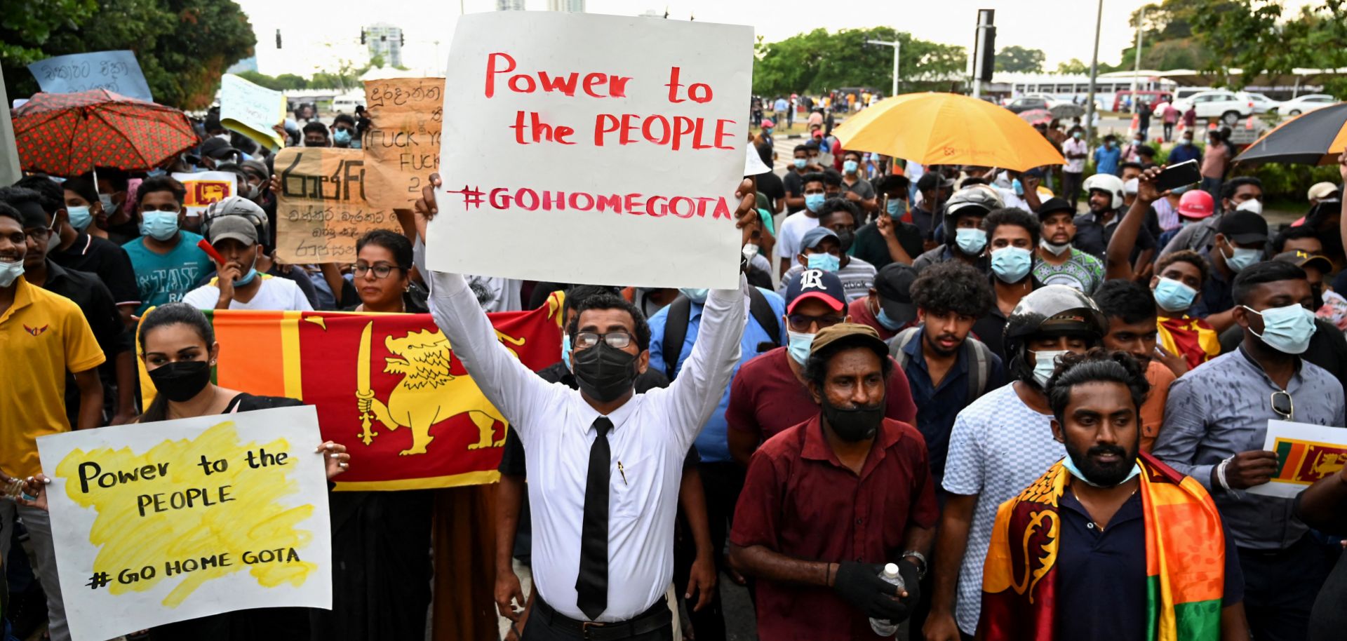 People hold up posters with ''#GoHomeGota,'' a slogan used to call for the resignation of Sri Lankan President Gotabaya Rajapaksa, at an anti-government protest in Colombo on April 5, 2022