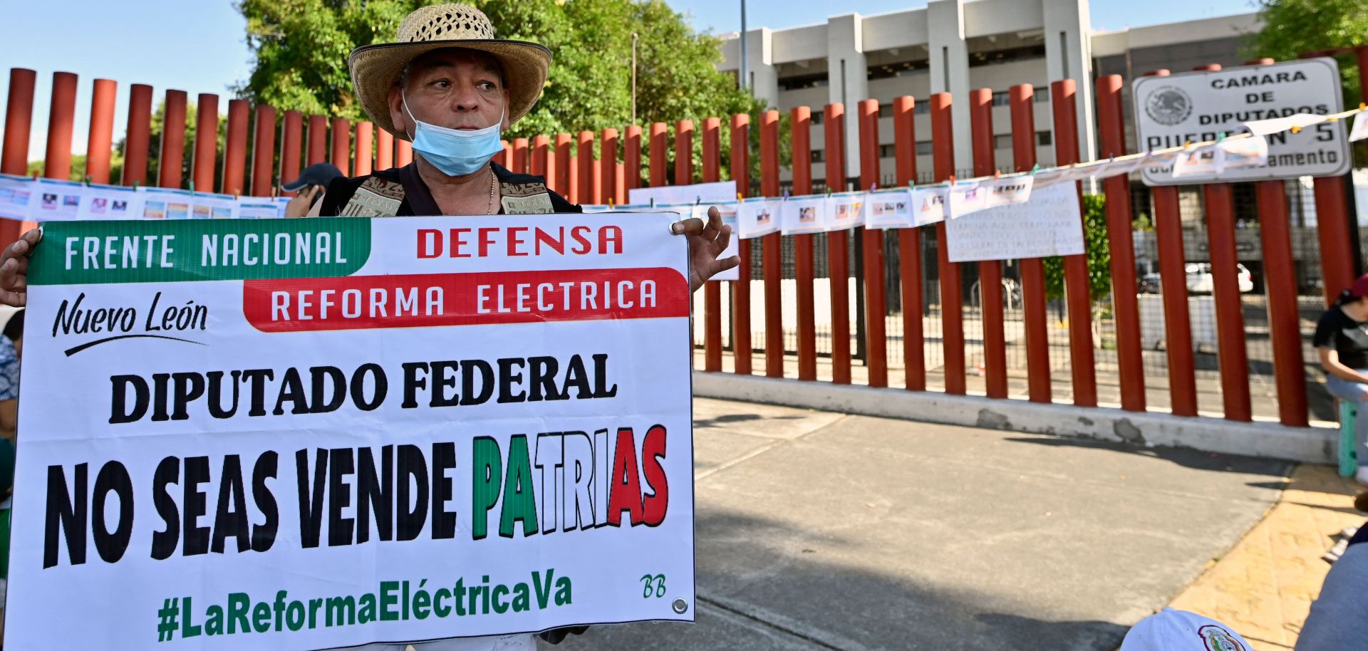 A demonstrator in Mexico City holds a sign in favor of President Andres Manuel Lopez Obrador's proposed electricity reform outside the building housing Mexico's Chamber of Deputies on April 17, 2022, as lawmakers hold a vote on the legislation. 