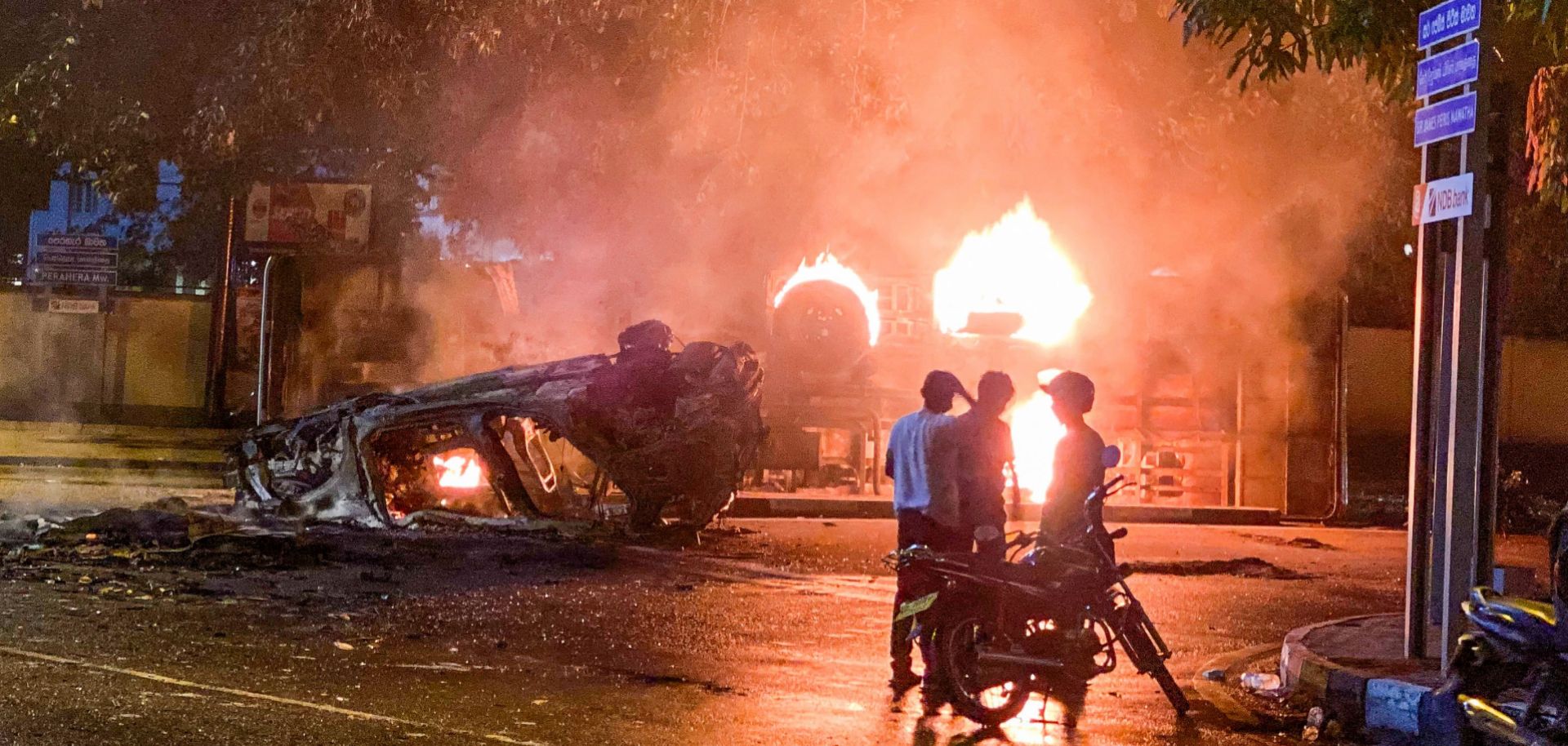 Flames engulf a vehicle belonging to the security personnel and a bus near outgoing Prime Minister Mahinda Rajapaksa's official residence in Colombo, Sri Lanka, May 9, 2022. 