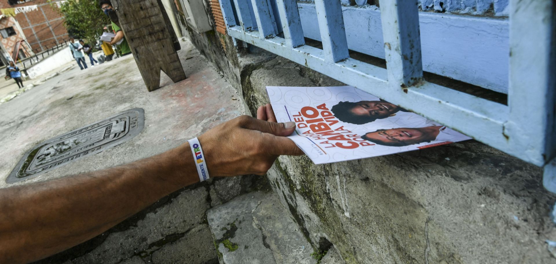 A volunteer slides a flyer into a house in Medellin, Colombia, supporting left-wing presidential candidate Gustavo Petro on May 27, 2022. 