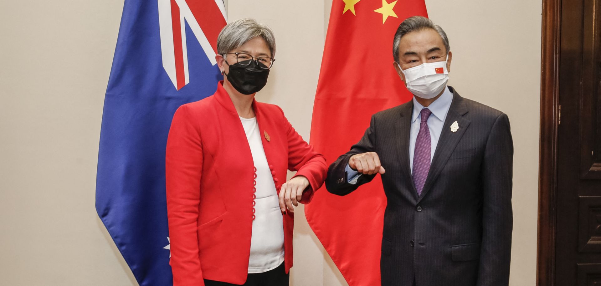 Australian Foreign Minister Penny Wong (left) bumps elbows with her Chinese counterpart Wang Yi on the sidelines of the G-20 Foreign Ministers Meeting in Bali, Indonesia, on July 8, 2022.