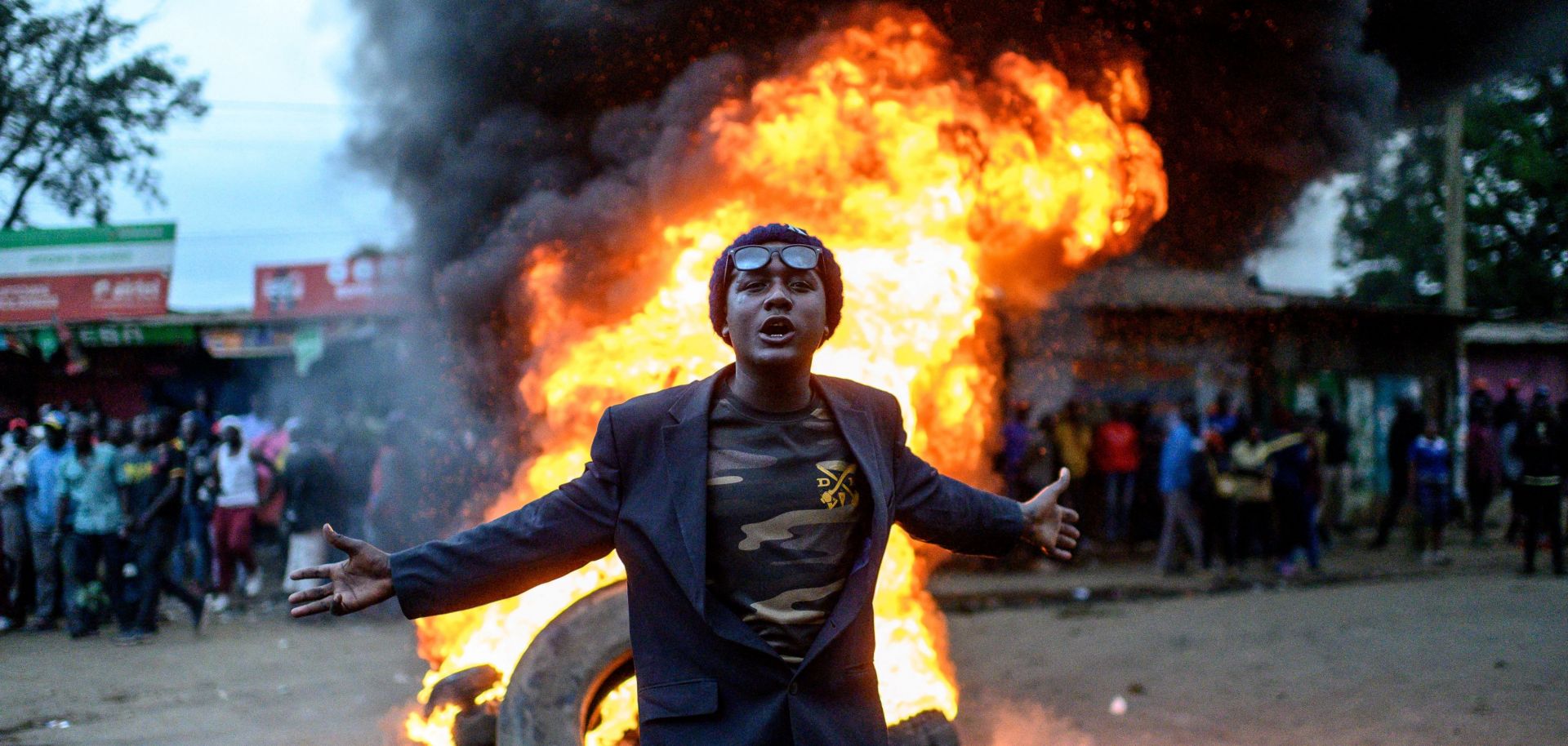 A supporter of Kenyan presidential candidate Raila Odinga gestures past a fire during a protest in Nairobi on Aug. 15, 2022, after William Ruto was declared the winner of the country's recent presidential race. 