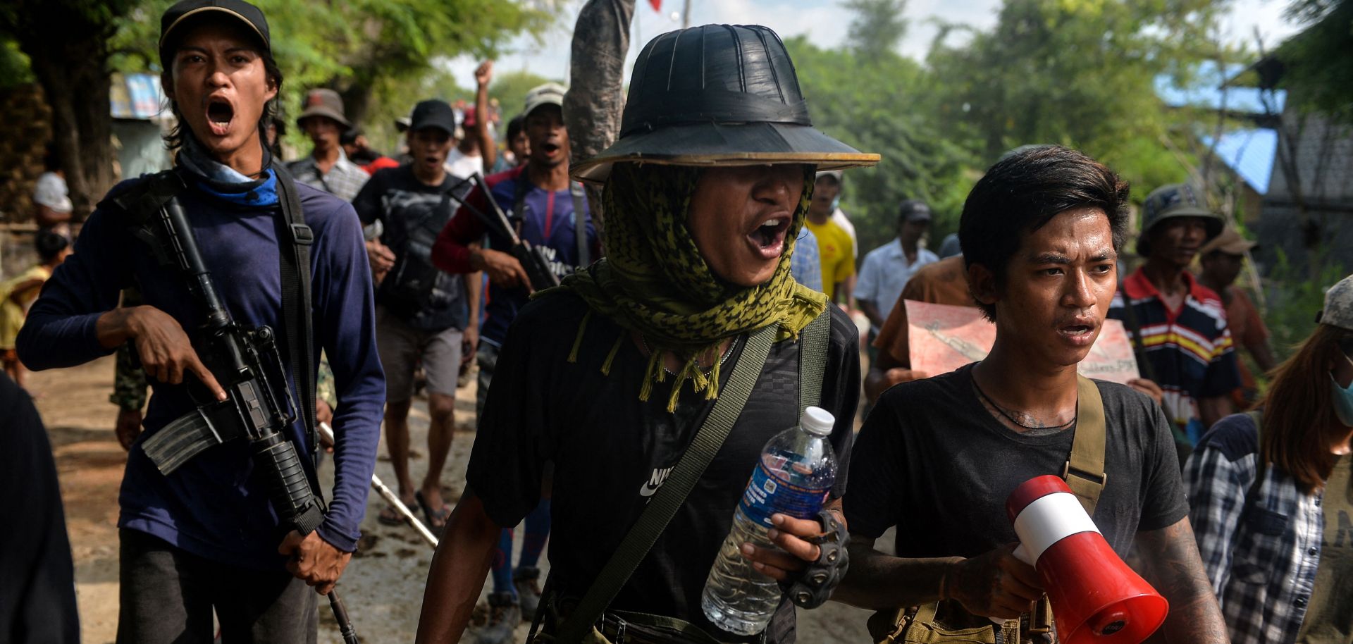 Anti-coup fighters escort protesters as they take part in a demonstration against the military coup in Sagaing, Myanmar, on Sept. 7, 2022. 