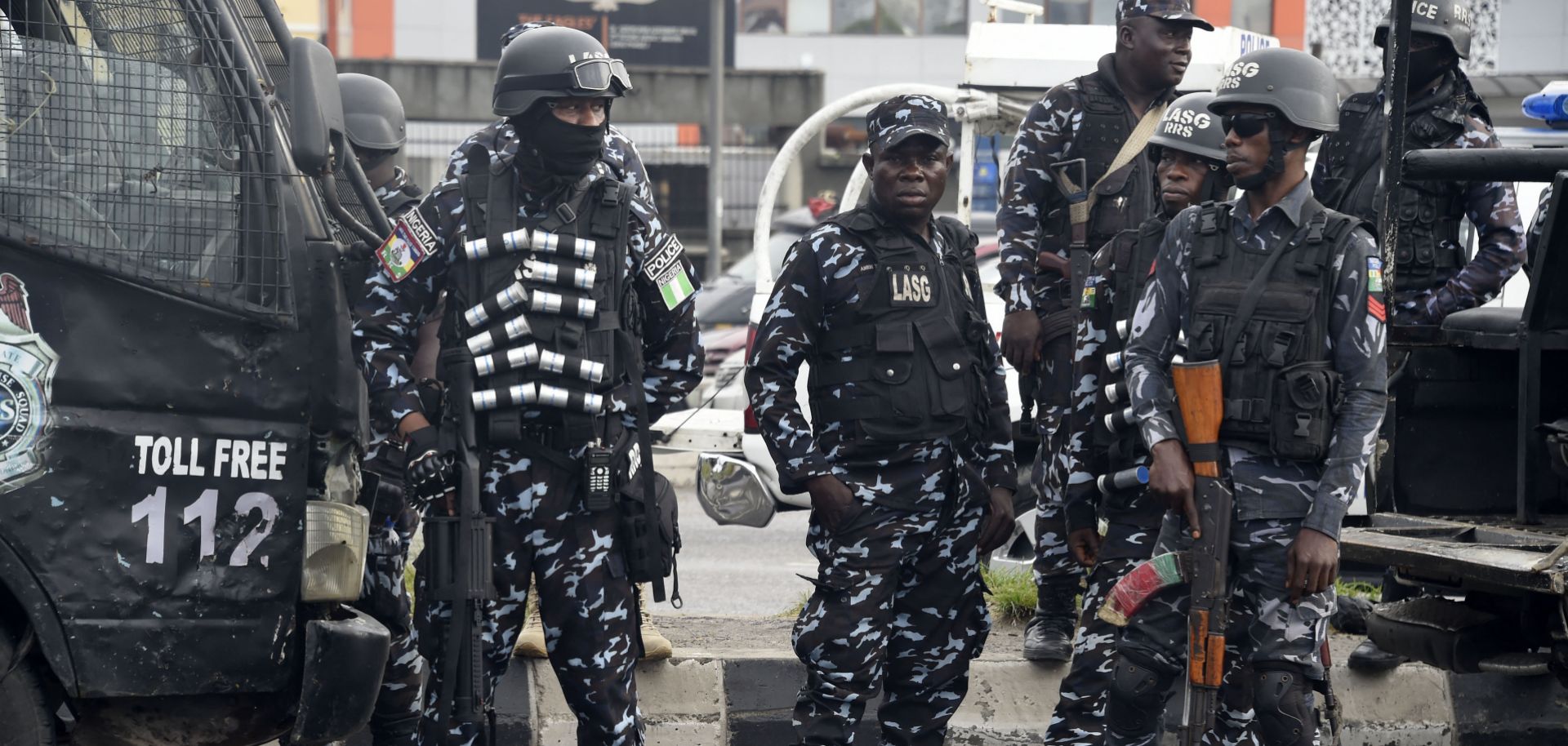Police officers stand on a street in Lagos on Oct. 1, 2022, as supporters march to campaign for a third-party candidate running in Nigeria's 2023 presidential election.