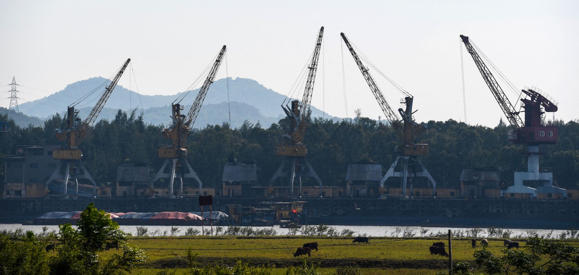 A photo taken on Oct. 14, 2022, shows cranes picking up coal at a port of the Pha Lai thermal power plant in Vietnam's Hai Duong province. 