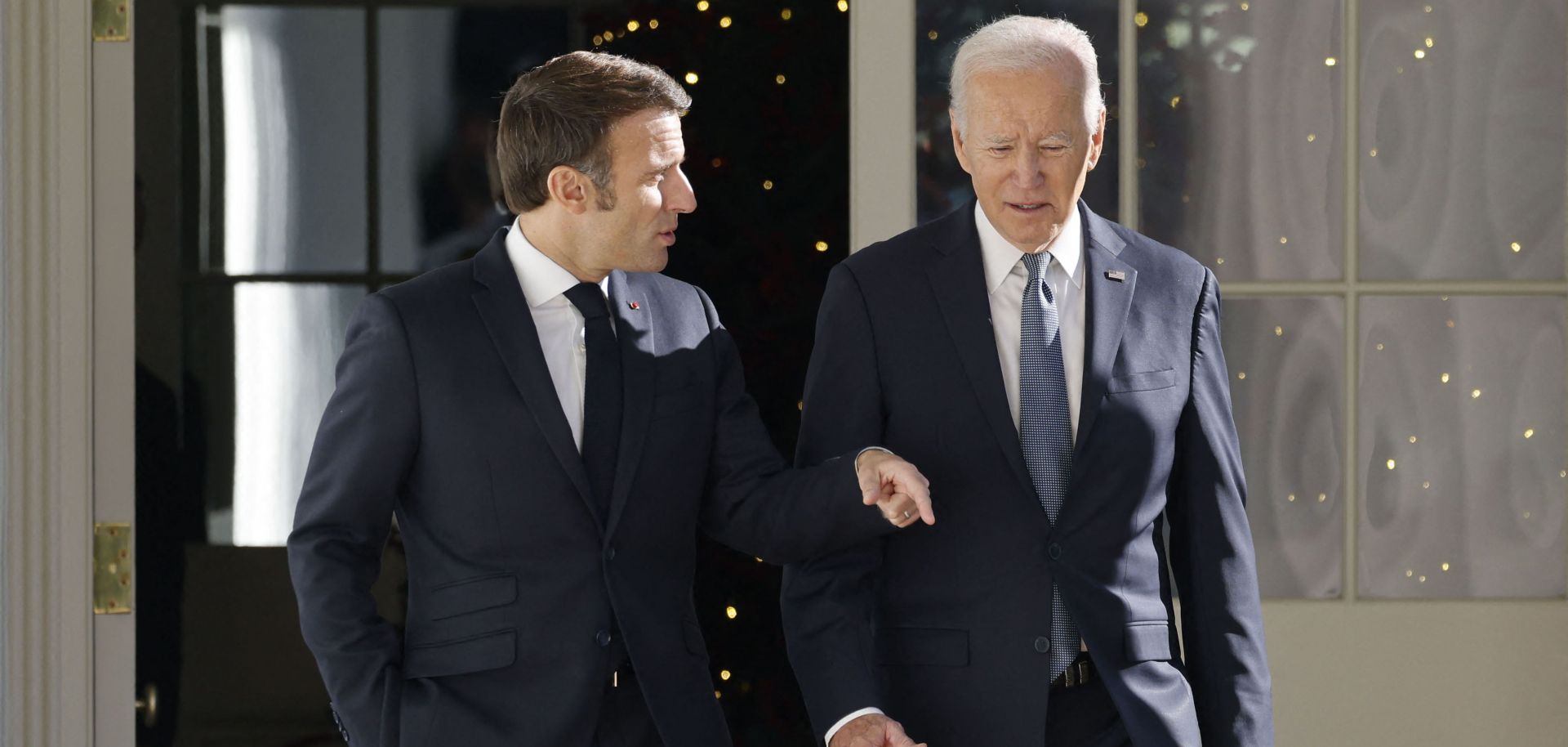 U.S. President Joe Biden (right) and French President Emmanuel Macron walk down the Colonnade at the White House in Washington, D.C., on Dec. 1, 2022. 