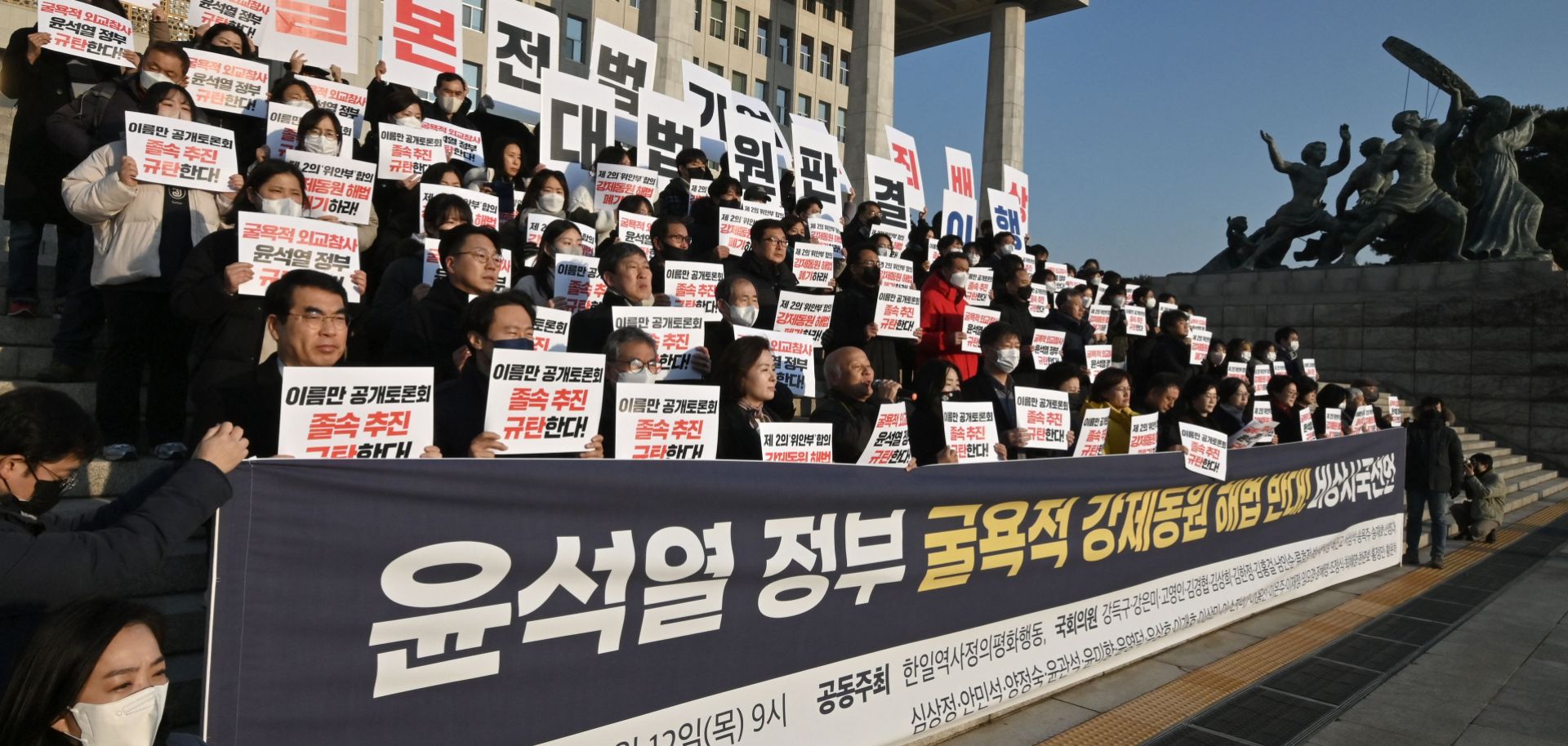 South Korean opposition lawmakers and supporters of the victims of Japan's wartime forced labor hold up placards during a protest against a public hearing on the issue at the National Assembly in Seoul on Jan. 12, 2023. 