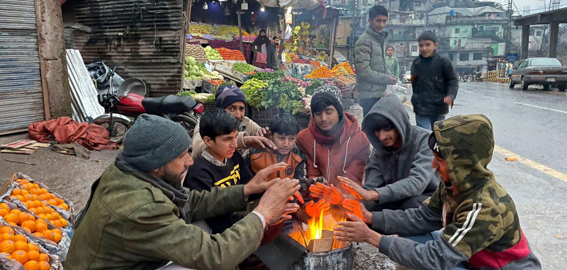 Vendors at a market warm themselves around a bonfire in Muzaffarabad, Pakistan, during a nationwide power outage on Jan. 23, 2023.