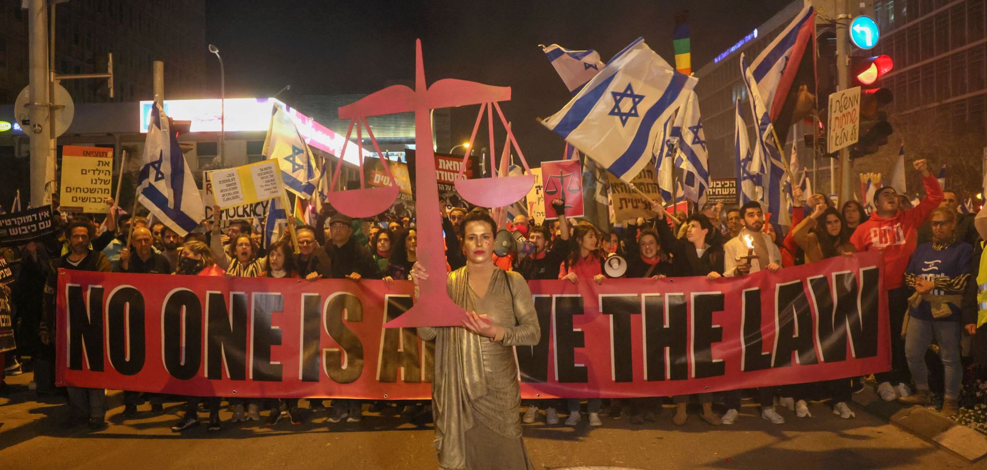 People march on a street in Tel Aviv, Israel, on Feb. 11, 2023, to protest against controversial judicial reforms being touted by the country's right-wing government. 