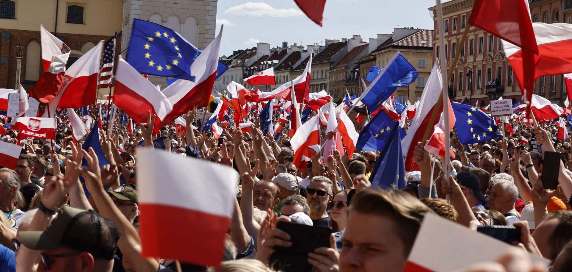 People wave EU and Polish flags during an anti-government rally organized by the opposition in Warsaw, Poland, on June 4, 2023. 