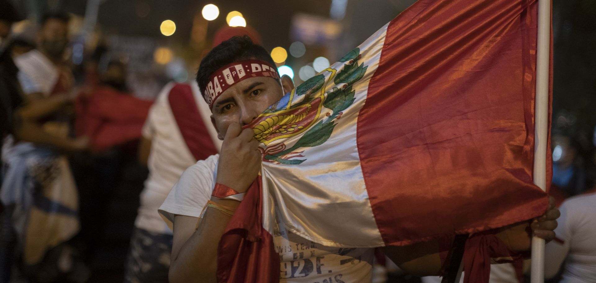 A supporter of ousted Peruvian President Martin Vizcarra embraces the country’s national flag during a protest in Lima, Peru, on Nov. 14, 2020.