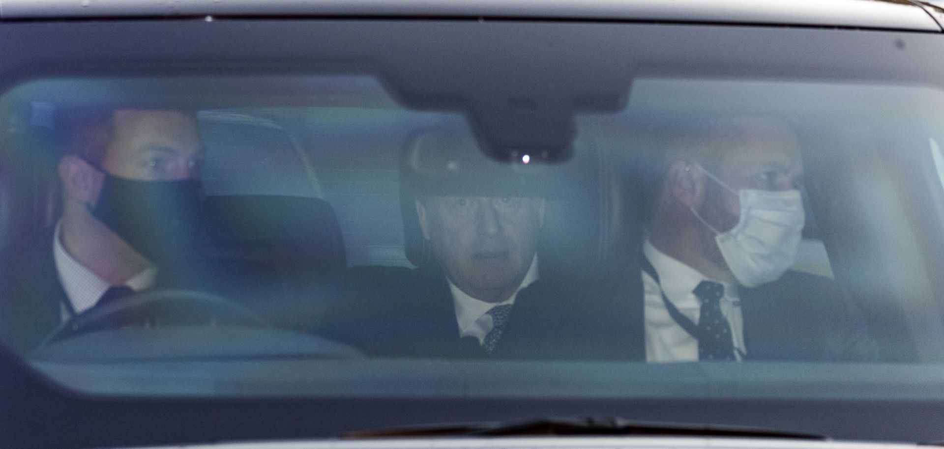 U.K. Prime Minister Boris Johnson (center) is seen in the backseat of a car in London, England, after holding a Prime Minister's Questions (PMQ) session in Parliament on Jan. 12, 2022. 