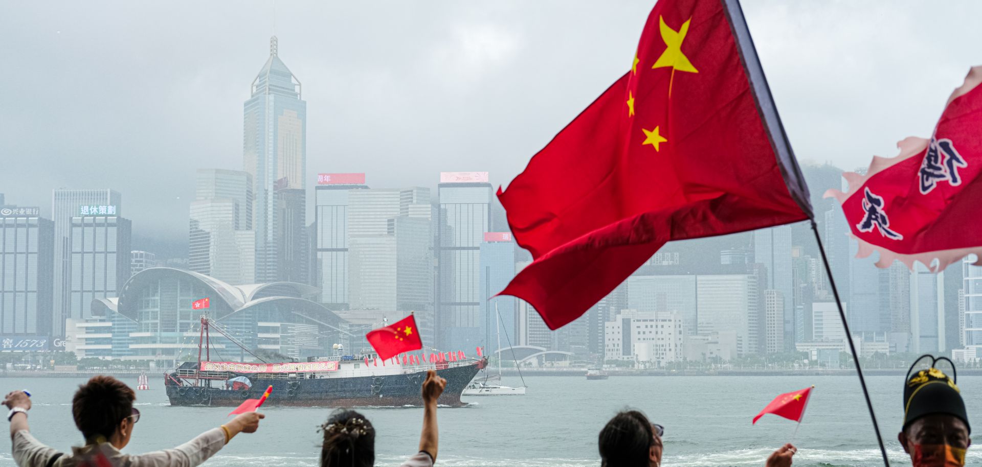 People in Hong Kong wave Chinese flags in celebration of the 26th anniversary of Hong Kong's handover from Britain to China on July 1, 2023. 