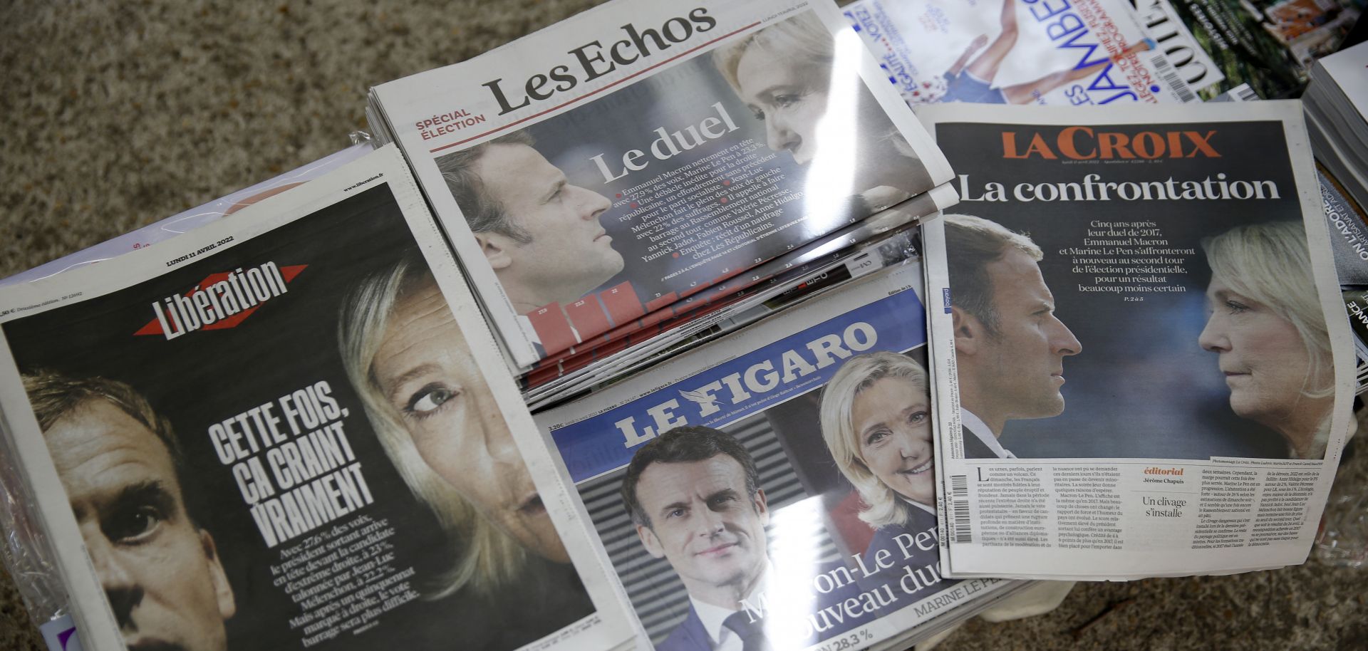Photos of French President Emmanuel Macron and right-wing candidate Marine Le Pen are displayed on the front pages of French newspapers at a newsstand in Paris on April 11, 2022, after Macron and Le Pen won the most and second-most votes, respectively, in the first round of France's presidential election. 