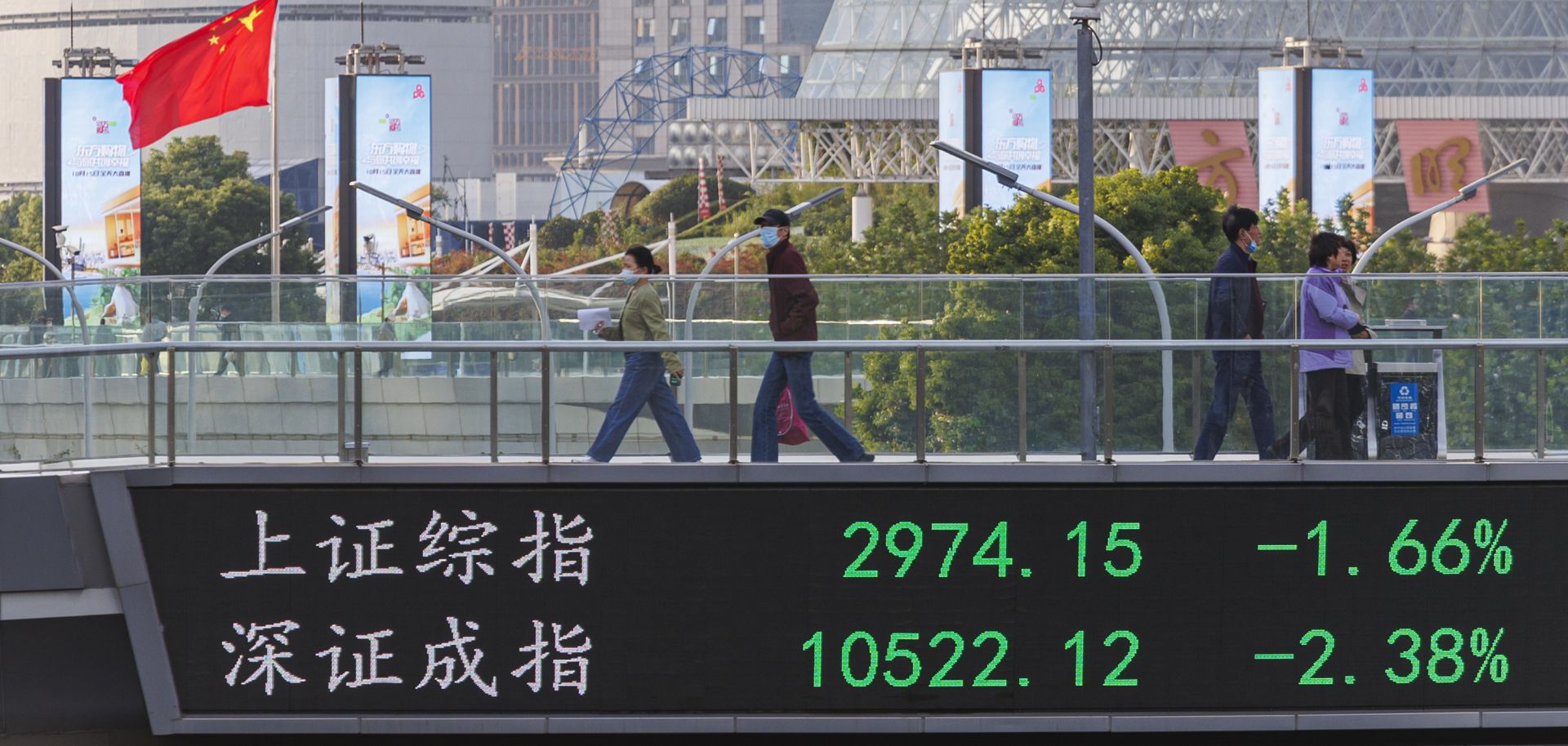 People walk on a pedestrian bridge that displays the numbers for the Shanghai Shenzhen stock indexes on Oct. 10, 2022, in Shanghai, China. 