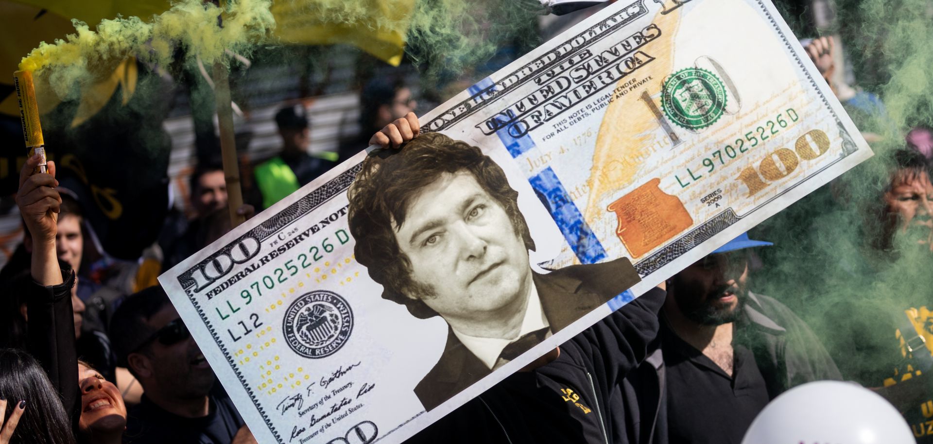 A supporter of Argentine presidential candidate Javier Milei, who has pledged to dollarize the country's economy, holds up a gigant fake U.S. dollar bill with Milei's face on it during a rally in Buenos Aires on Sept. 25, 2023. 