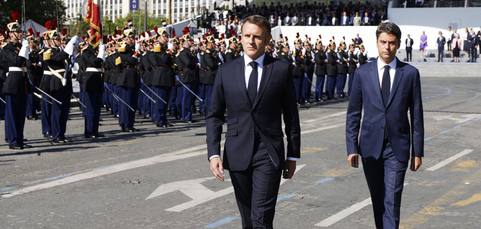 French President Emmanuel Macron (center, in foreground) and French Prime Minister Gabriel Attal review the troops during the Bastille Day military parade in Paris, France, on July 14, 2024.