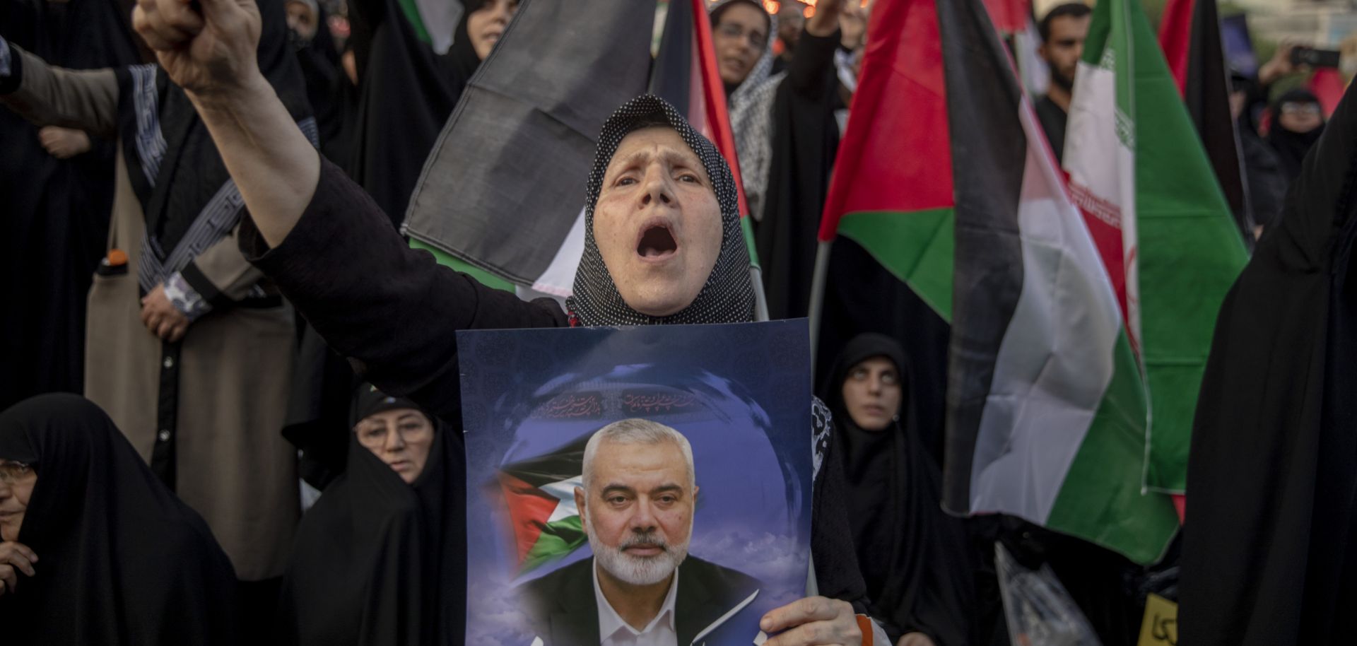 A woman carries a picture of slain Hamas leader Ismail Haniyeh during a protest in Tehran, Iran, on July 31, 2024. 