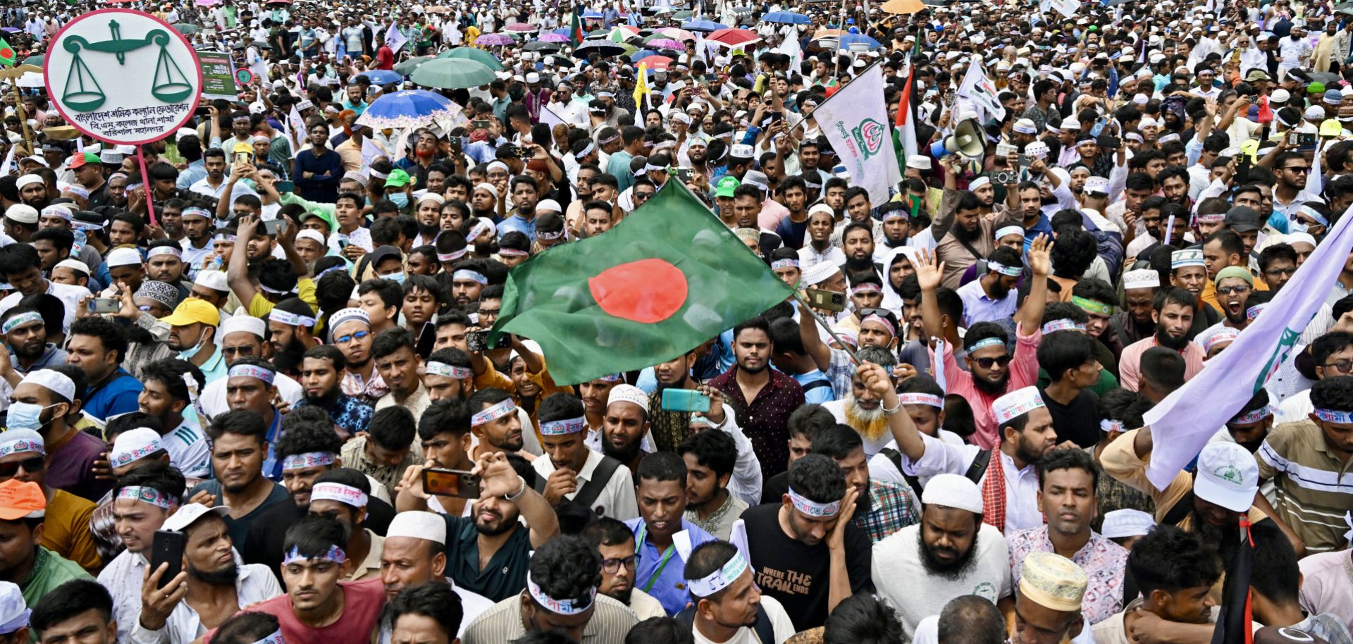 Supporters of Bangladesh's Jamaat-e-Islami party wave the national flag in Dhaka during a rally held to call for the introduction of a proportional representation system in the country's forthcoming general election on July 19, 2025. 