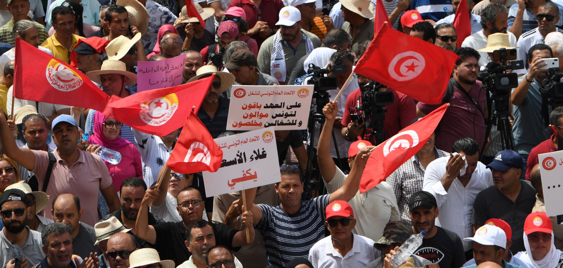 Supporters of Tunisia's General Labour Union (UGTT) wave the national flag during a rally in Tunis on Aug. 21, 2025.
