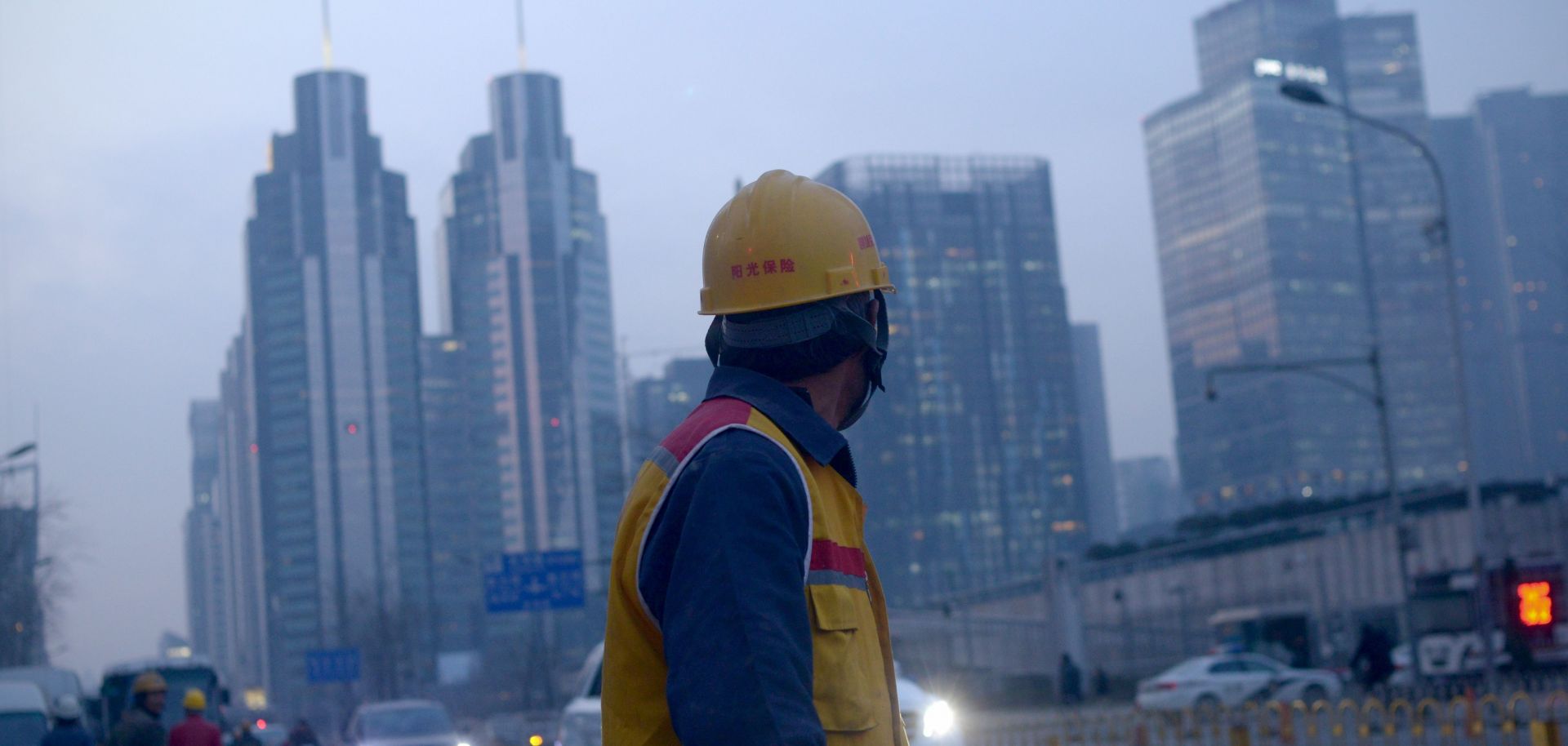 A Chinese worker looks on as he walks along a street in Beijing after finishing his shift.