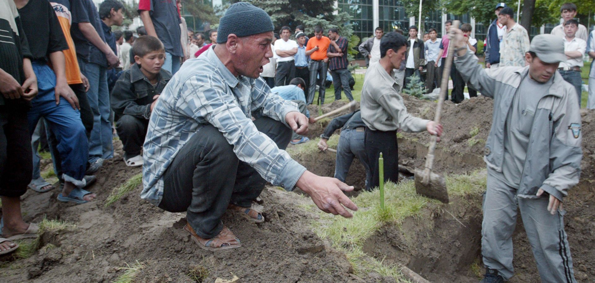 A man shouts as residents dig graves for the bodies of victims of clashes between government forces and local protesters prior to a funeral ceremony at the central square in the Uzbek town of Andijan, on May 14, 2005. Hundreds of people were reported killed after security forces opened fire on demonstrators.