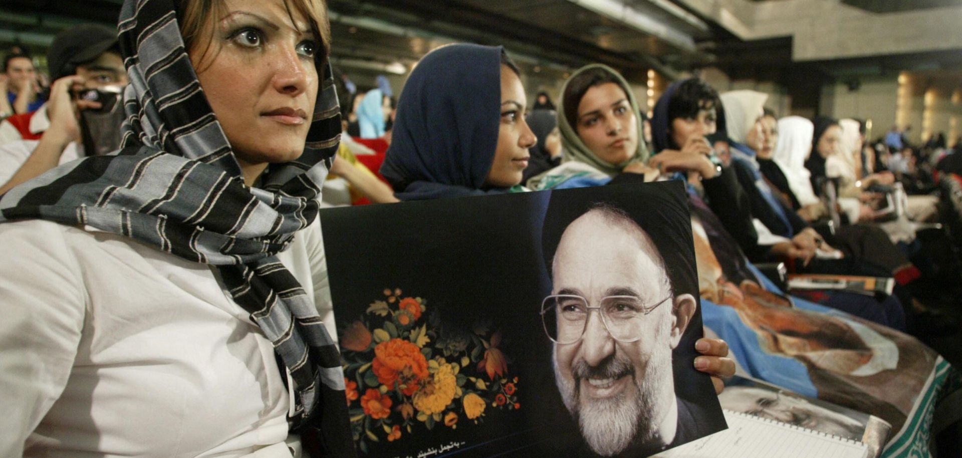 A woman holds a picture of outgoing reformist President Mohammad Khatami on July 31, 2005, during a ceremony in Tehran marking his last week of service. 