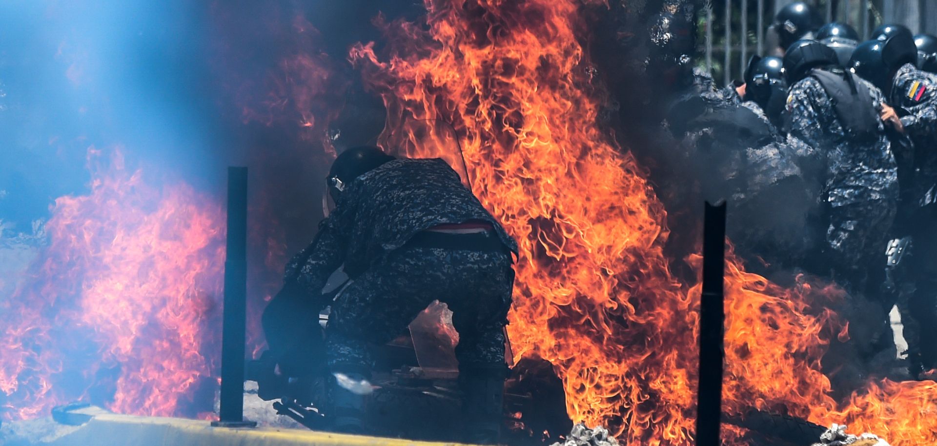 Police officers engulfed in flames from an incendiary device during protests in Caracas on July 30.
