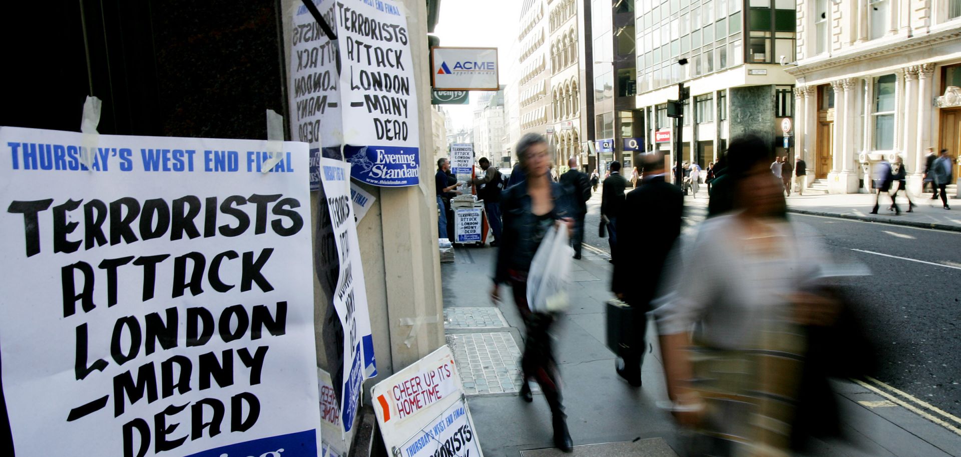 Pedestrians walk past a newspaper stand announcing terrorist attacks in London on July 7, 2005.